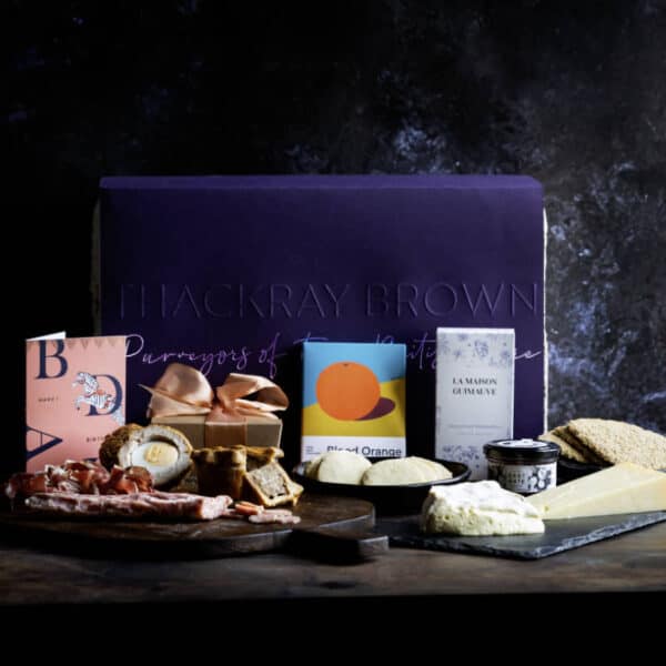 luxury british artisan food and drink hamper with food in front of hamper